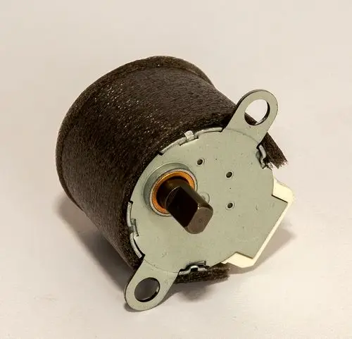Daikin Pendelmotor, runder Motor mit metallischer Unterseite und einem Anschluss, der für die Verwendung in Heizlösungen konzipiert ist.